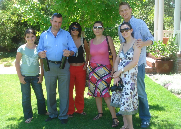 two couples pose with their friends at a park