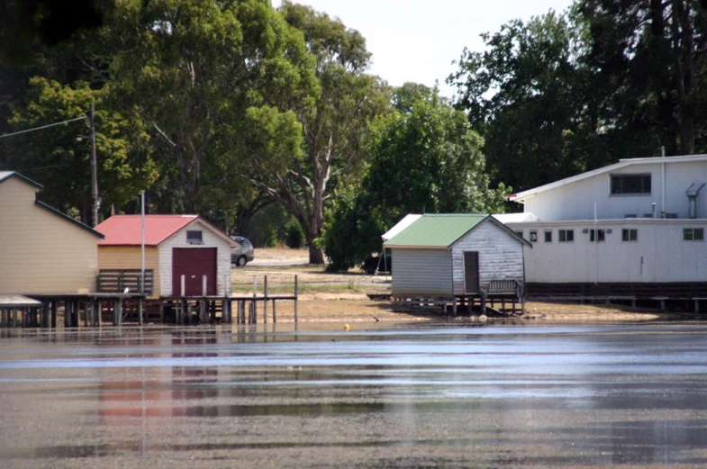 a group of houses and tables sitting on the shoreline