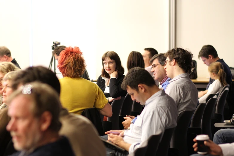 many people are sitting together in an auditorium