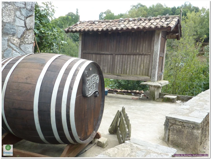 a large wooden barrel with an asian symbol sitting on a stone surface