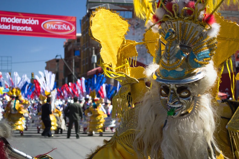 a masked person in yellow and red costume standing on street