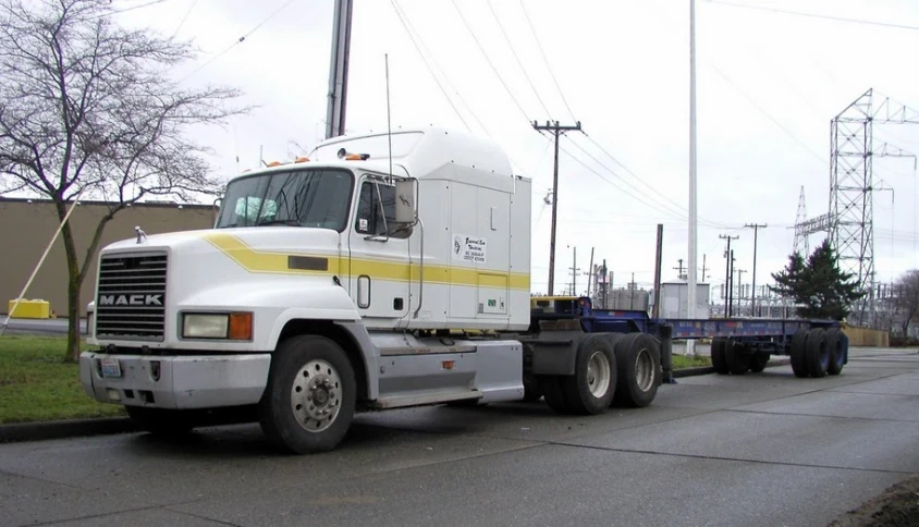 large truck and trailer driving down a city street