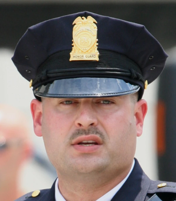 a police officer in uniform standing next to another police man