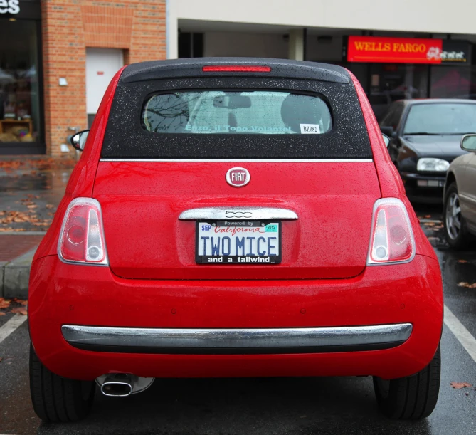 a red car with a license plate on it's trunk