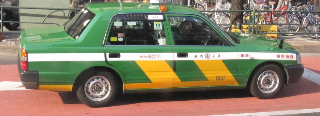 a green taxi is parked in a parking lot