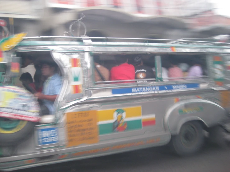 a small vehicle with passengers in it on the street