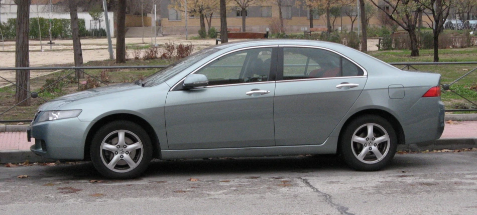 a grey car sitting next to an open fire hydrant