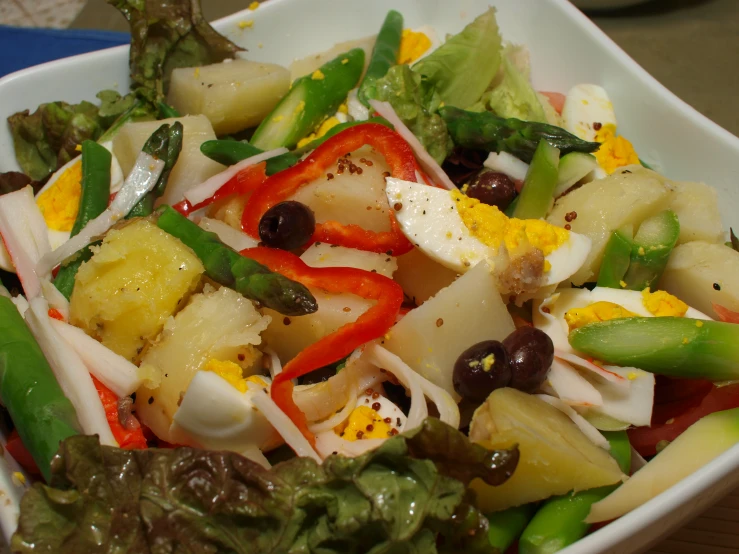 the salad in the bowl is mixed with colorful fruits