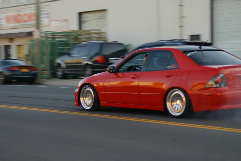 an orange car driving down the street on its wheels