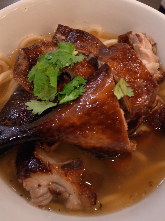 a white bowl filled with meat and noodles