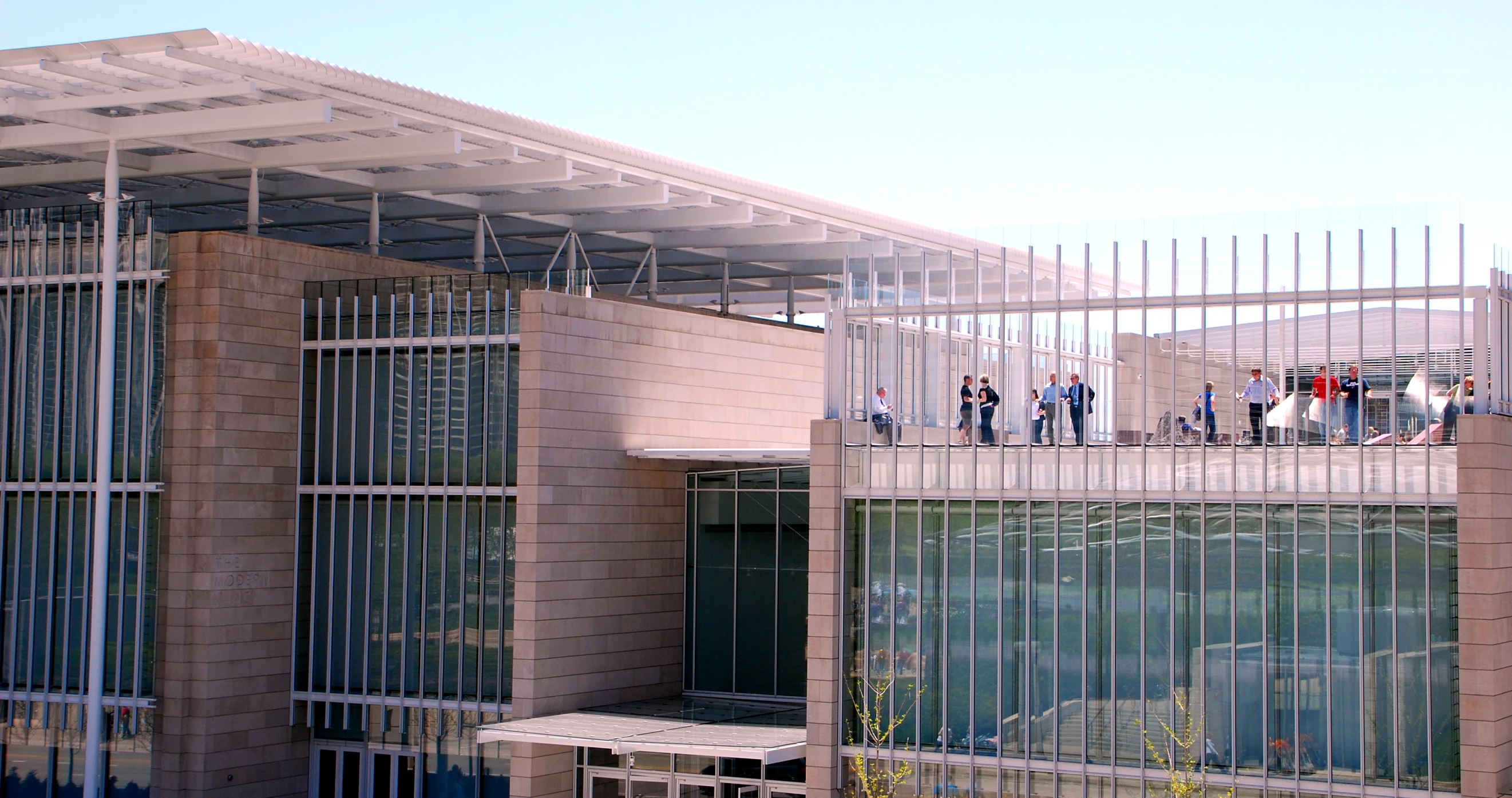 a group of people stand on a balcony above a building