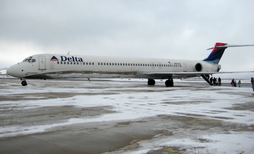 the white and blue airplane is parked on the runway