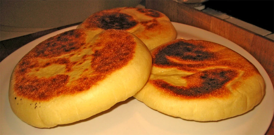 three brown spots on white bread on a white plate