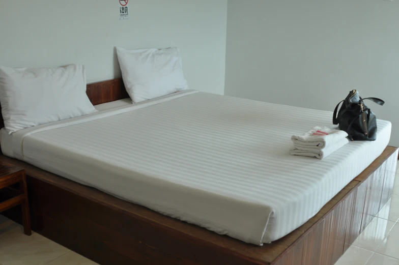 a el bed with two pillows and white sheets