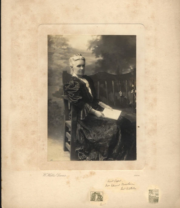 antique pograph of a woman in gown holding a paper