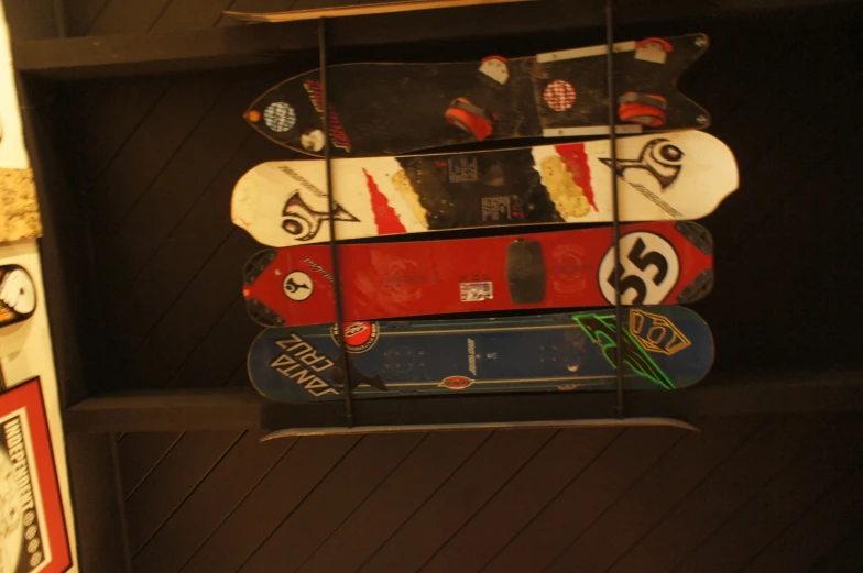 five skateboards on display in a dark room