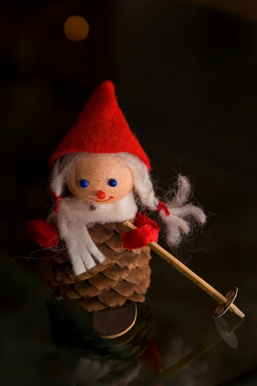 a small, little doll is standing inside of a pine cone