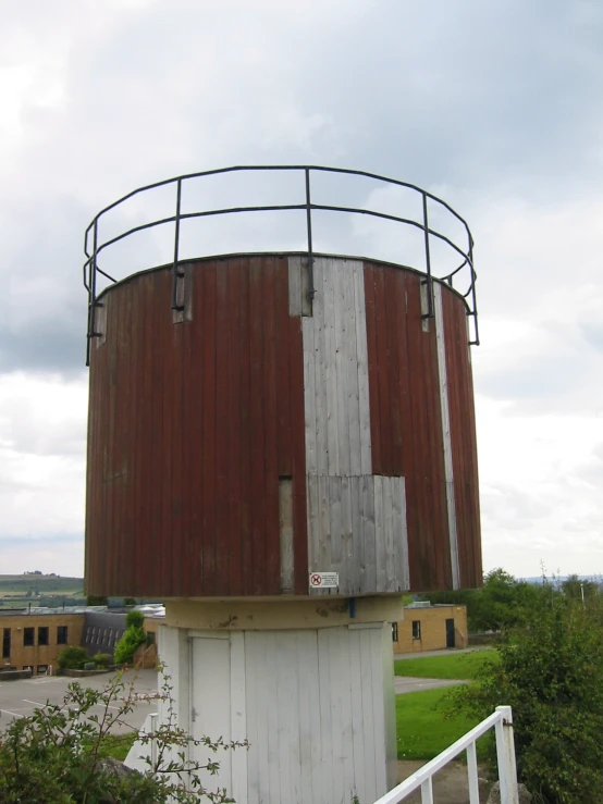 an old wooden tower with metal pipes on it