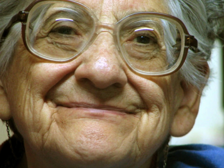 an older woman smiling and wearing eyeglasses