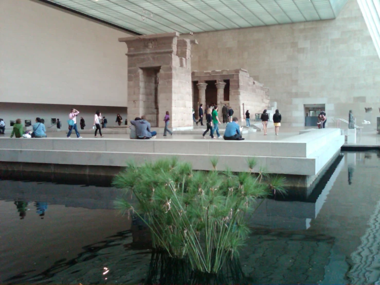 people at the entrance of a museum building near a river