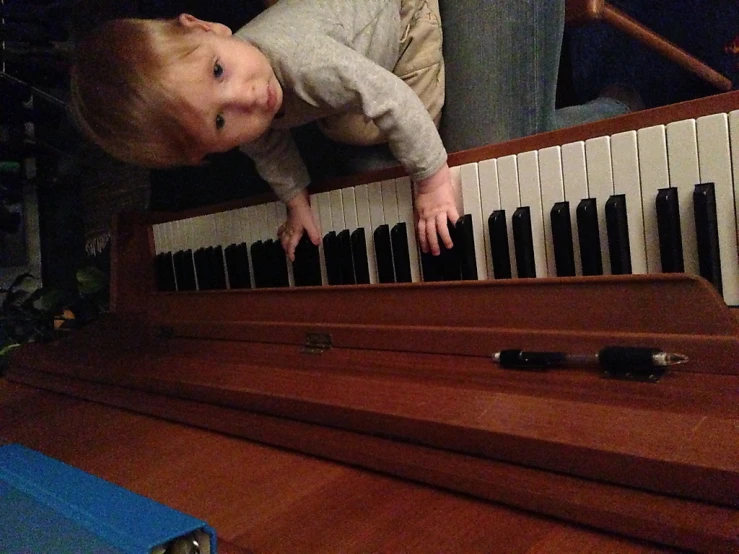 a small child is sitting by the piano keys