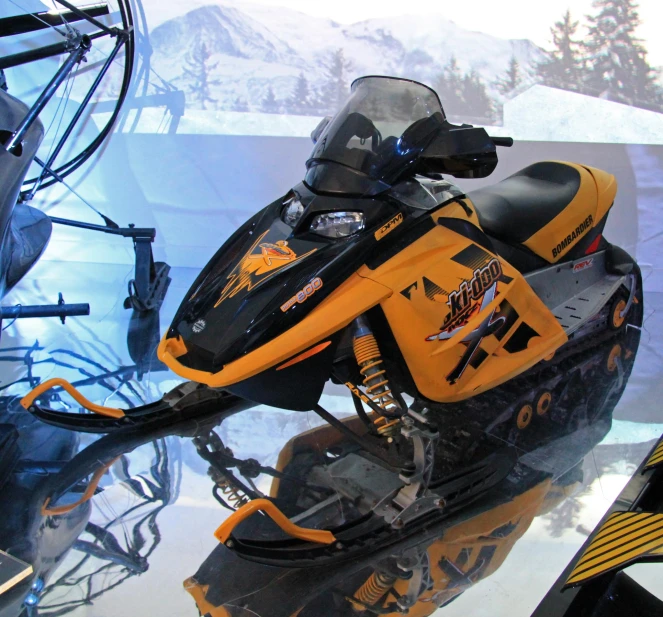 a small black and yellow snowmobile is sitting on display