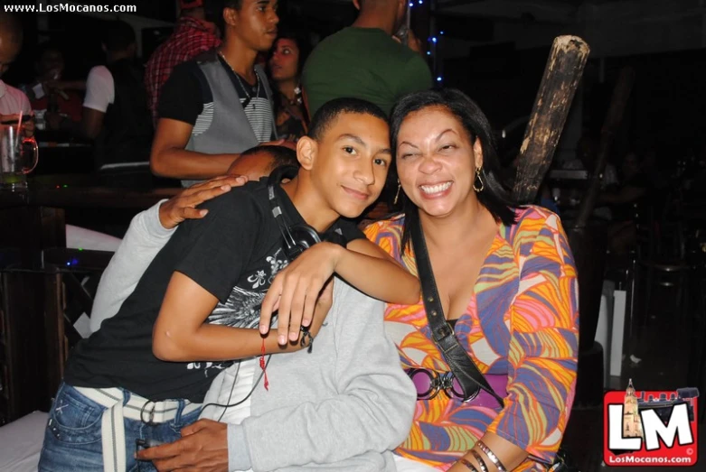 a woman sitting next to a boy while posing for a picture