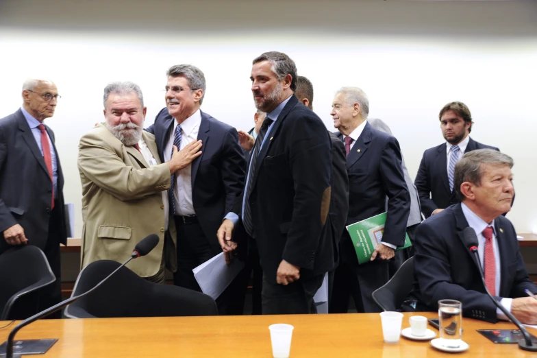 a group of men standing around a wooden table