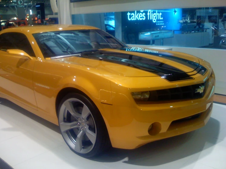 an orange sports car sitting in a showroom