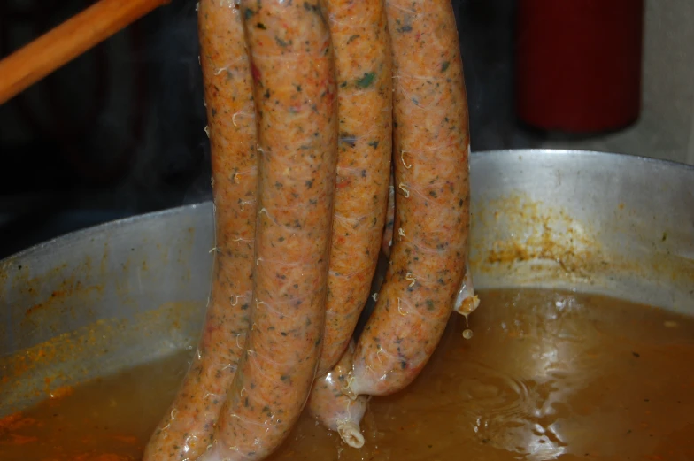 some very tasty looking looking looking sausages cooking in a pot