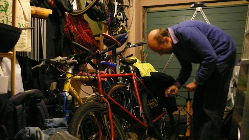 a man is hanging bikes with shoes on the ground