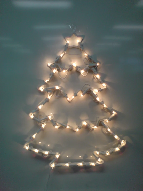 a small lighted christmas tree on a window