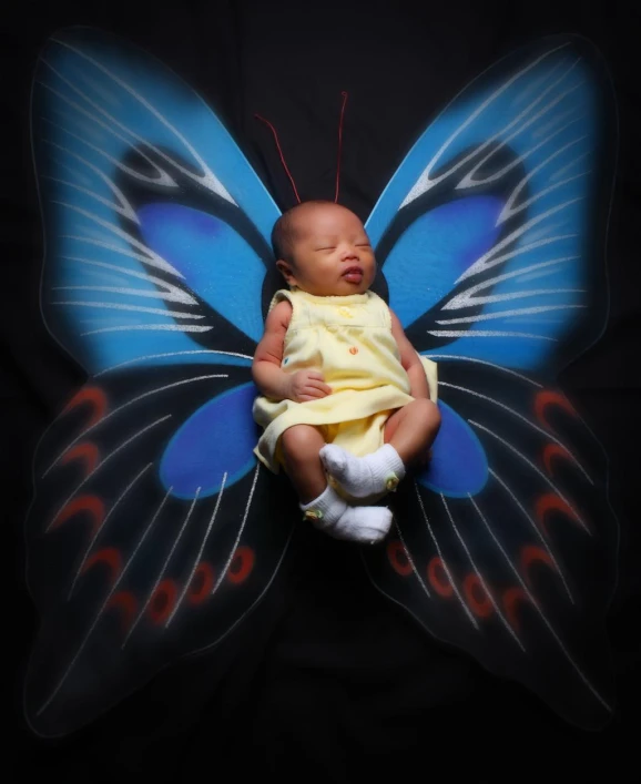 the newborn baby is sleeping with a erfly wings