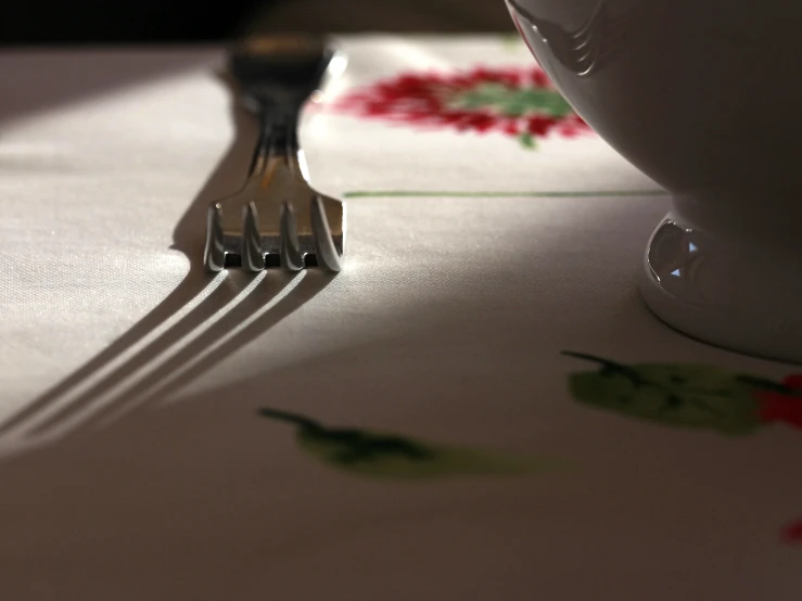 two forks in front of a plate with a cup of coffee