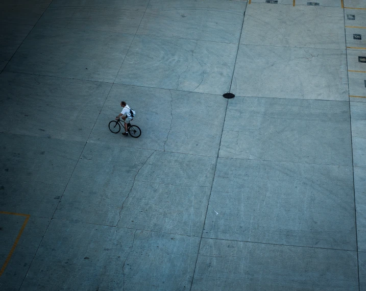 a lone person on a bike rides in an outdoor area