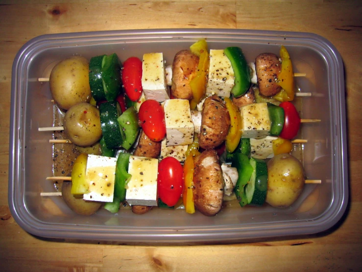 a plastic container filled with food sitting on a wooden surface