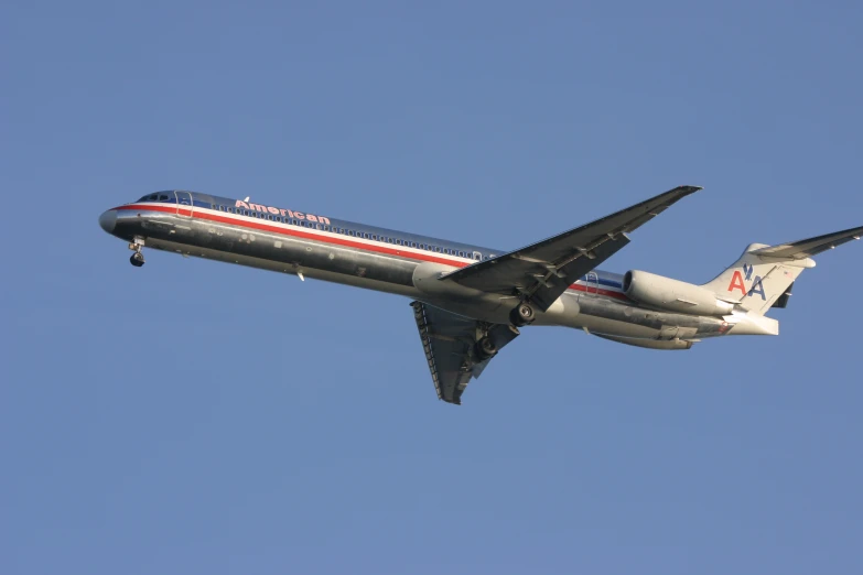 an american airlines airplane in mid flight with its landing gear down