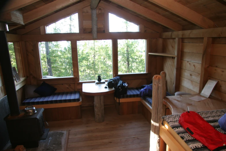 a cabin with two windows, bunk beds and table