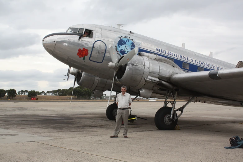 a man standing in front of a silver plane