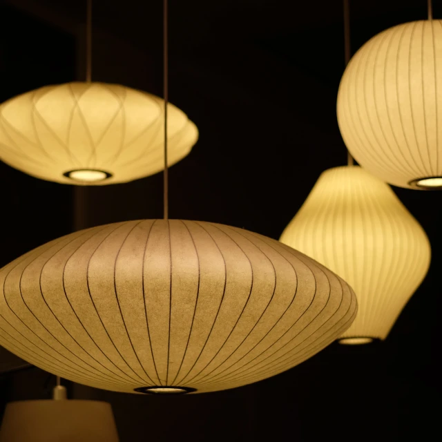 a group of lamps hanging from strings in a room