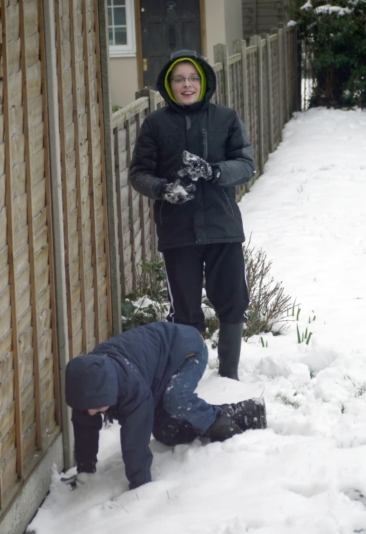 a lady standing next to her son in the snow