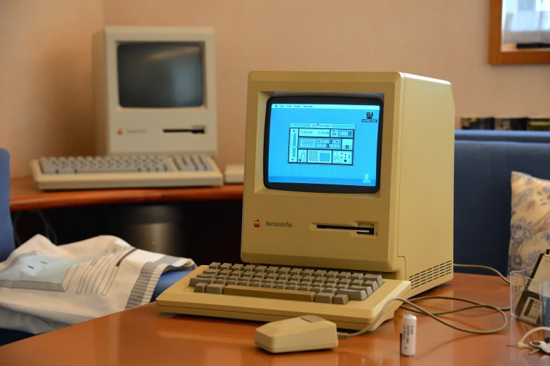 an old computer sits on a table in front of a monitor