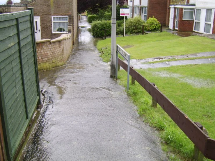 a rain soaked street with water running down the side walk