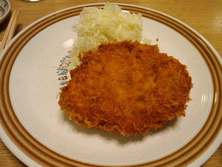 a plate of food containing a fried egg sandwich and coleslaw