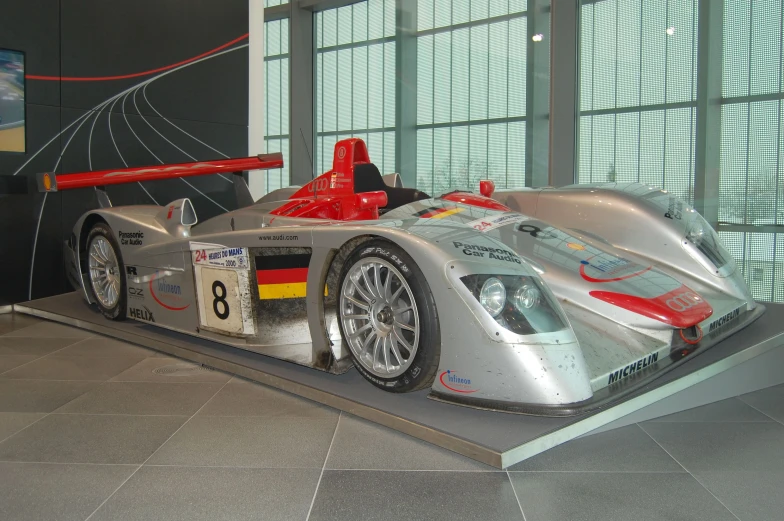 a sporty race car sits on display in a museum