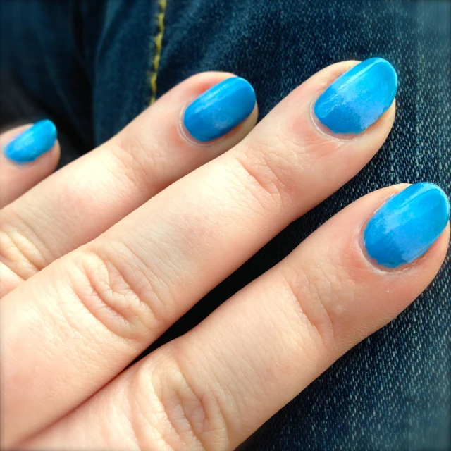 a woman's hand with a blue manicure