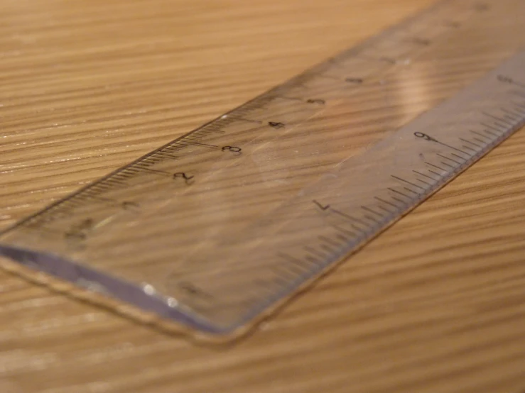 a ruler lying on a table with wood grain