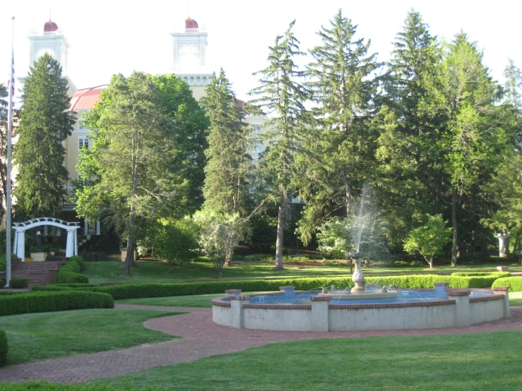 an outdoor fountain with trees and buildings in the background