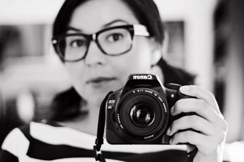 a woman holding up a camera to take a po