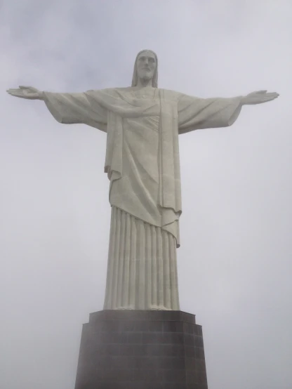 a large statue standing in the air under a gray sky